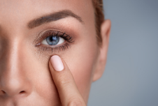 a lady pointing to her tear troughs for dermal filler